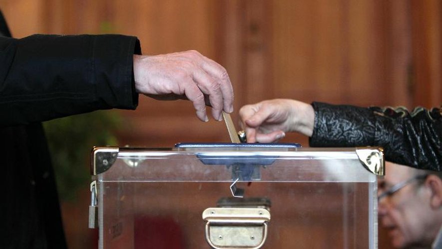 Un homme dépose son bulletin de vote dans l'urne à Rouen le 29 mars 2015 au deuxième tour des élections départementales