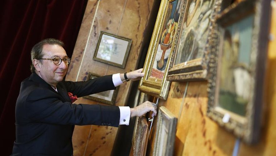 Photo prise le 10 mars 2015 montrant le commissaire-priseur Jean-Pierre Osenat présentant des toiles de Pierre Bonnard avant des enchères, le 29 mars 2015 à Fontainebleau