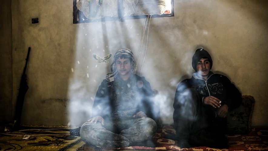 Des combattants kurdes se reposent dans une maison dans la banlieue de Kobané d'où a été chassé le groupe Etat islamique le 30 mars 2015