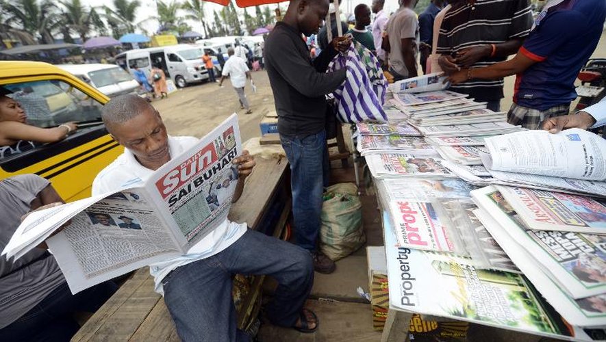 Des Nigérians lisent les journaux alignés sur un stand de Lagos le 1er avril 2015, au lendemain de la victoire de l'oppositeur Muhammadu Buhari dans l'élection présidentielle