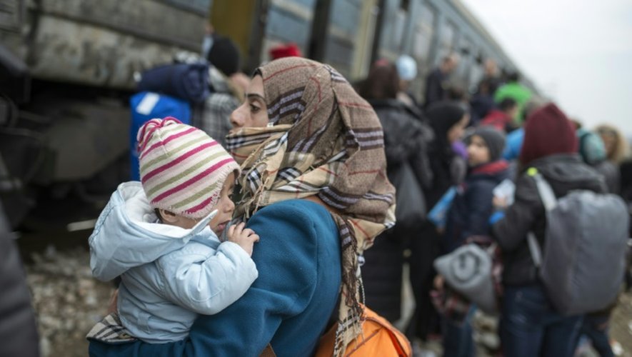 Des migrants embarquent à bord d'un train à destination de la Serbie le 18 février 2016 près de Gevgelija à la frontière entre la Macédoine et la Grèce