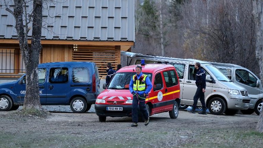 Des gendarmes à proximité des véhicules contenant les corps des trois victimes de l'avalanche du massif des Ecrins, le 1er avril 2015 à Vallouise dans les Alpes françaises