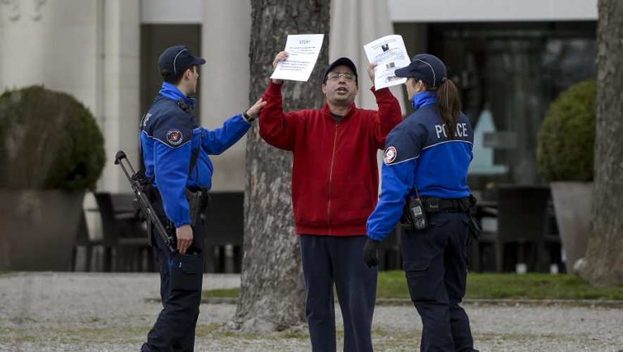 Un homme protestant contre les négociations nucléaires est appréhendé par des policiers devant  l'hôtel Beau-Rivage Palace à Lausanne, le 2 avril 2015