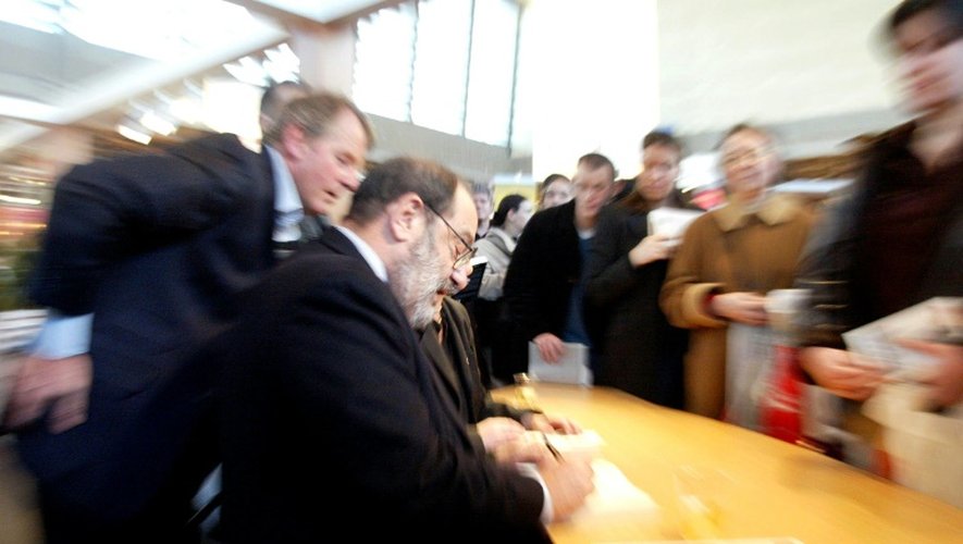 l'écrivain italien Umberto Eco signe l'un de ses livres, le 23 mars 2002 lors d'une séance de dédicace dans le cadre du 22e Salon du livre de Paris