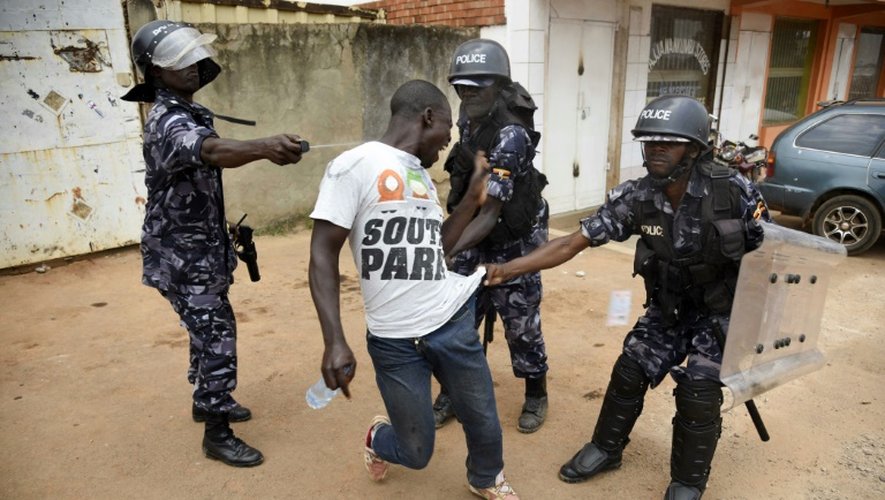 Des policiers ougandais envoient du gaz lacrymogène à un opposant au régime lors du second tour des élection s présidentielles, le 19 février 2016 à Kampala