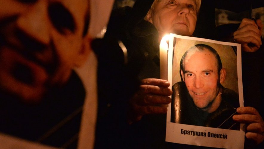 Une participante à la commémoration de la répression du Maïdan, le 19 février à Lviv  montre la photo d'un tué lors des  manifestations il y a deux ans
