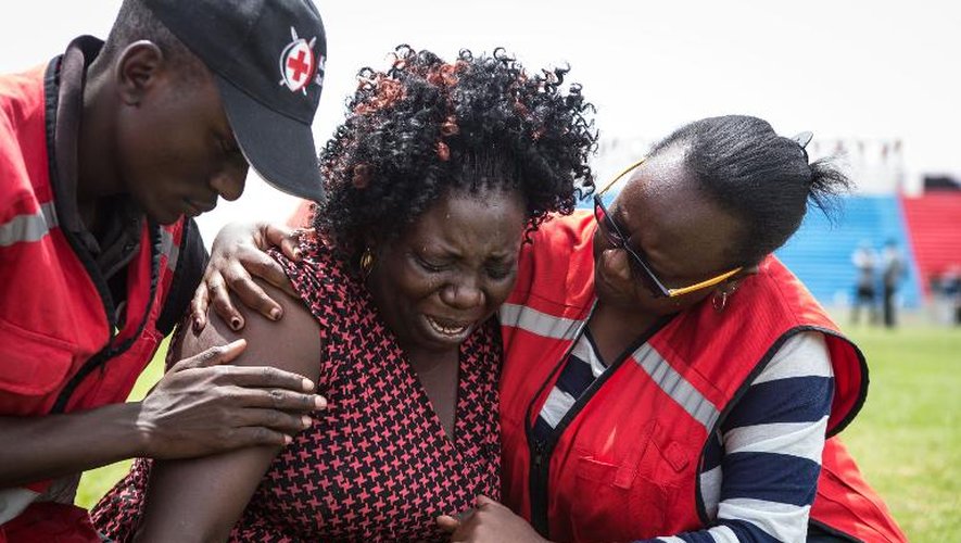 Des membres de la Croix-Rouge aident, le 5 avril 2015 à Nairobi, dans le stade Nyayo, une femme venant d'apprendre que l'un de ses proches fait partie des personnes tuées par les shebab à l'université de Garissa
