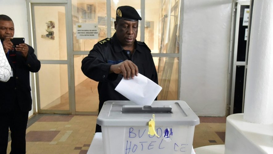 Un policier dépose son bulletin dans l'urne dans un bureau de vote à Niamey, le 21 février 2016