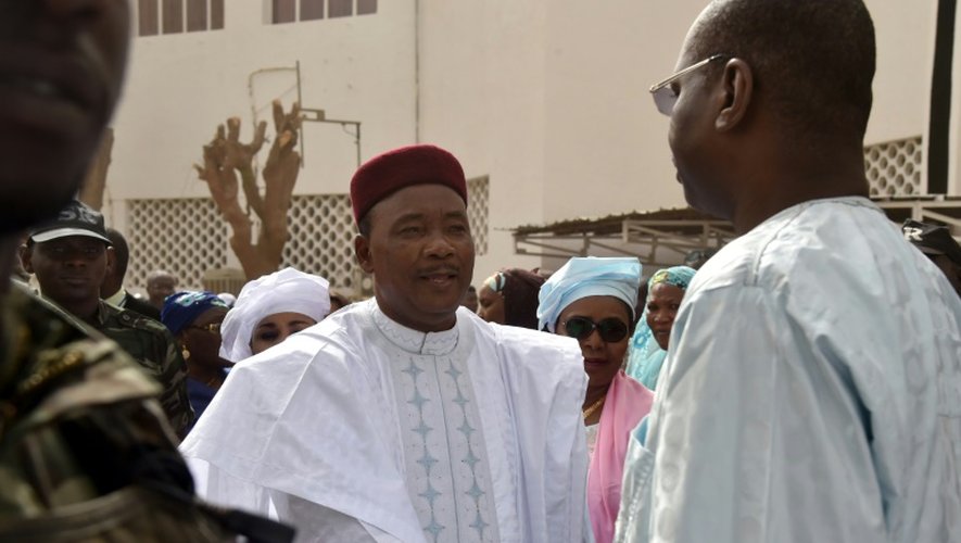 Le président nigérien sortant et candidat à sa succession Mahamadou Issoufou (c) salue le président de la commission électorale indépendante Ibrahim Boube (d) devant le bureau de vote de l'hôtel de ville à Niamey le 21 février 2016