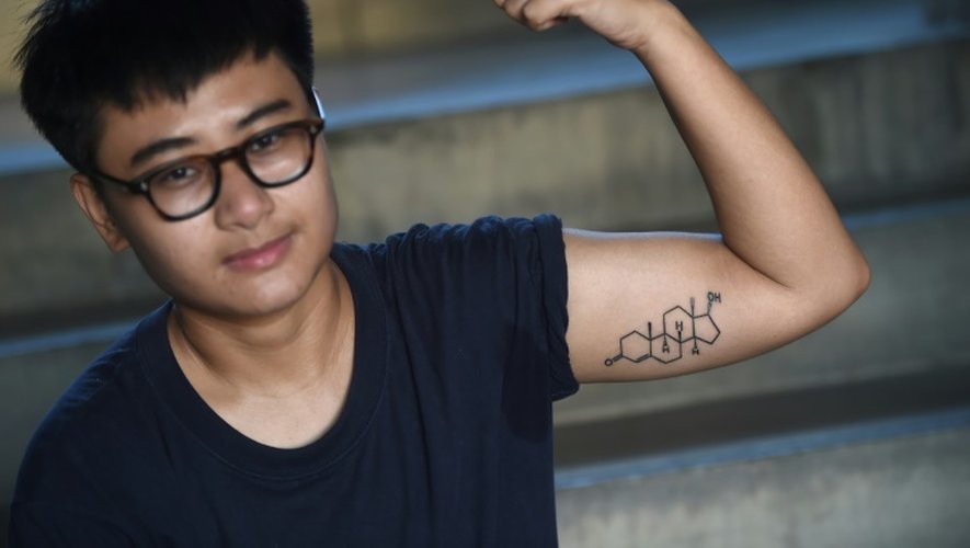 Chalit Pongpitakwiset, qui suit un traitement pour devenir un homme montre son tatouage où est inscrit la formule de la testostérone, le 14 janvier 2016 à Bangkok