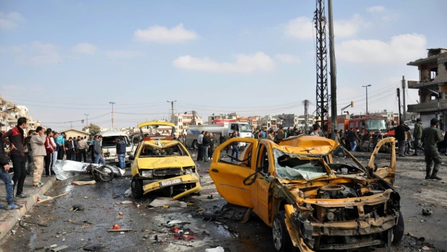 Dégâts après le double attentat à la voiture piégée dans la banlieue de Homs le 21 février 2016