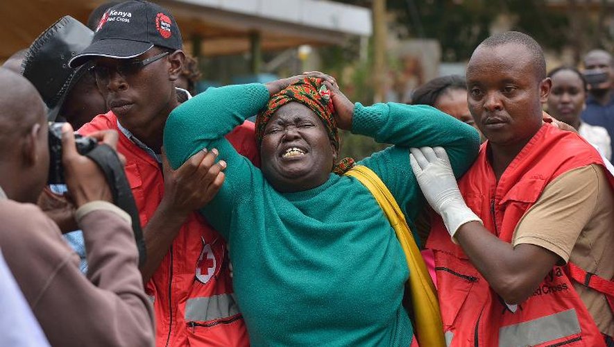 Des membres de la Croix-Rouge aident un membre de la famille d'un des étudiants tués à Garissa par des shebab somaliens, le 3 avril 2015 à Nairobi