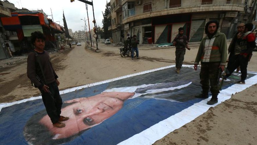 Des combattants de la coalition de forces islamistes foulent au pied un portrait du président syrien Bachar Al-Assad le 29 mars 2015 à Idleb, dans le nord de la Syrie