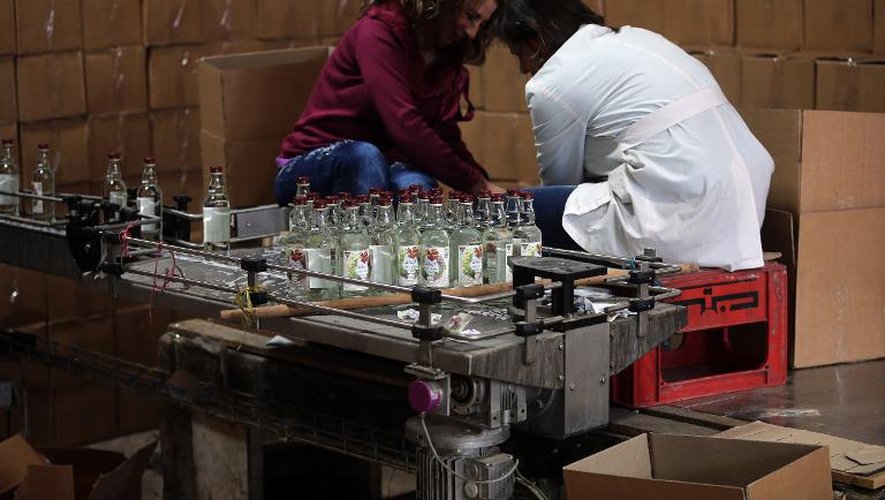 Des employées de l'entreprise syrienne Al Minas remplissent des bouteilles d'arak dans l'usine située à Homs (centre de la Syrie), le 26 mars 2015
