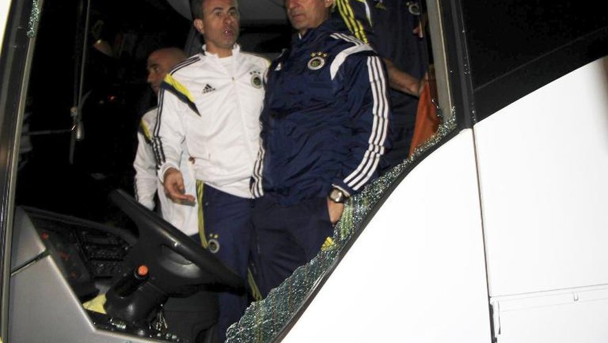 L'entraîneur de Fenerbahce Ismail Kartal (d) constate les dégâts causés par des tirs de fusils sur leur bus, le 4 avril 2015 près de Trabzon