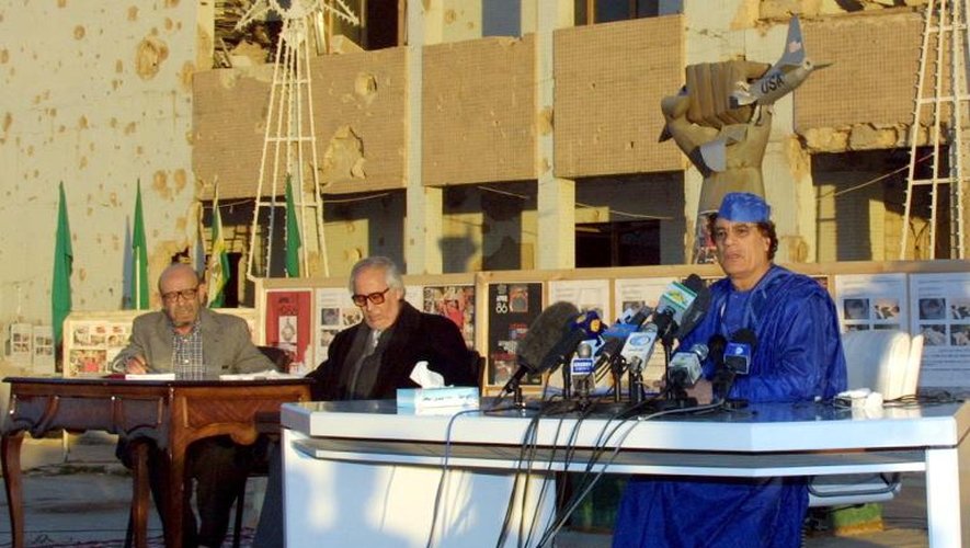 Le dirigeant libyen Mouammar Kadhafi (d) tient le 5 février 2001 une conférence de presse avec deux avocats devant la "Maison de la résistance" du complexe de Bab Al-Aziziya, à Tripoli, sa résidence portant les stigmates des frappes américaines de 1986