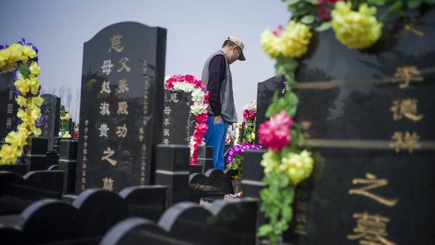 Un homme se recueille le 4 avril 2015 dans le cimetière de Dagantangcun, 30 km à l'est de Pékin, la veille des festivités de Qingming, le jour "où l'on balaye les tombes des ancêtres"