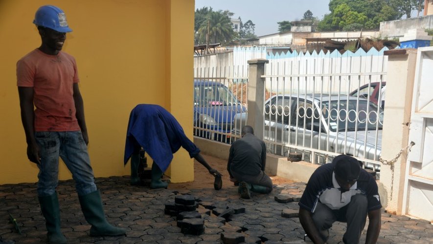 Des Camerounais pavent le sol avec des pavés fabriqués avec des déchets plastiques recyclés, le 1er février 2016 à Yaoundé