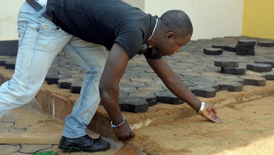 Un Camerounais pave le sol avec des pavés fabriqués avec des déchets plastiques recyclés, le 1er février 2016 à Yaoundé