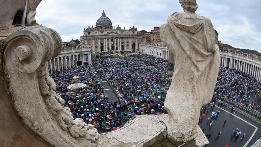 Les fidèles catholiques suivent sous la pluie la messe des Pâques présidée par le pape François, le 5 avril 2015 sur la Place Saint-Pierre au Vatican