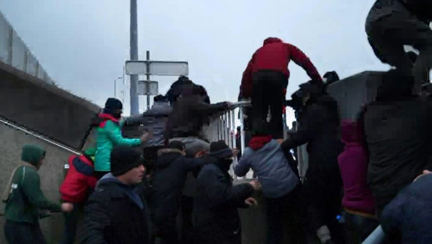 Capture d'écran d'une video de Taranis News en date du 24 janvier 2016, de migrants défonçant une clôture pour monter sur un ferry à Calais