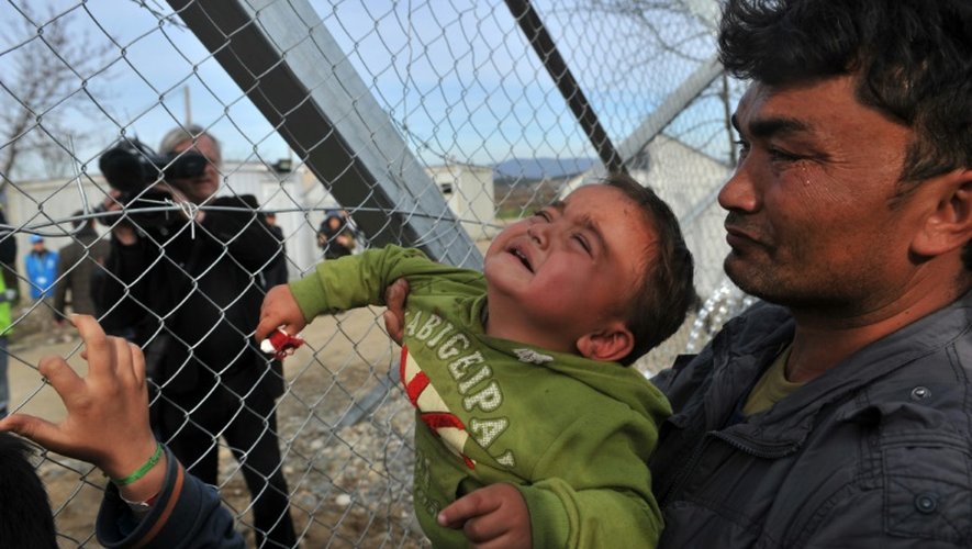 Un réfugié et son bébé pleurent lors d'une manifestation contre le blocage pour les afghans du poste frontière gréco-macédonien d'Idomeni, le 22 février 2016