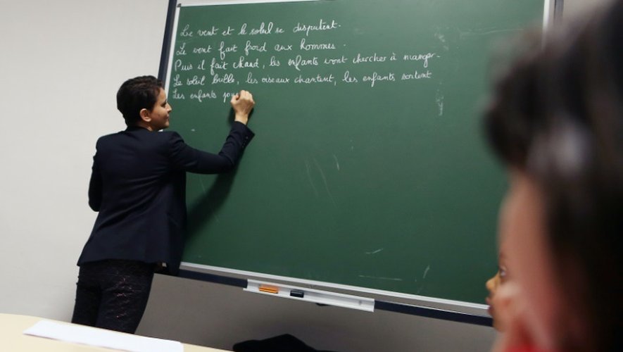La ministre de l'Education nationale Najat Vallaud-Belkacem écrit sur le tableau lors de sa visite d'une école au Havre le 22 février 2016