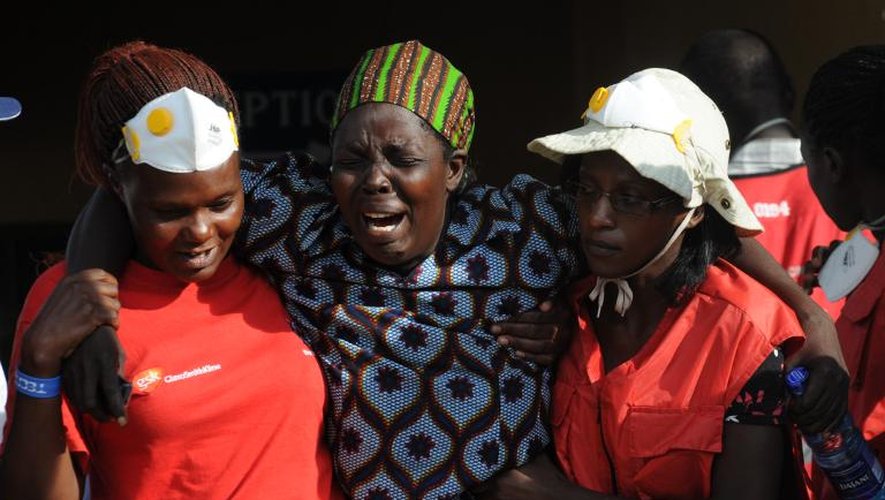 Une femme éplorée est aidée par deux membres de la Croix rouge kenyane dans la salle mortuaire à Nairobi où reposent les cadavres de ceux tués lors du massacre de l'université de Garissa