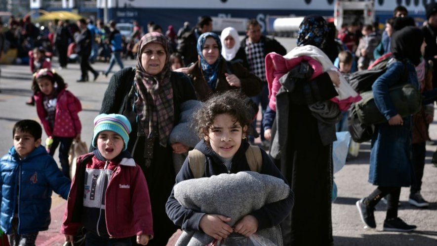 Des réfugiés syriens et irakiens embarquent sur des bus le 23 février 2016 depuis le port du Pirée à Athènes vers la frontière gréco-macédonienne