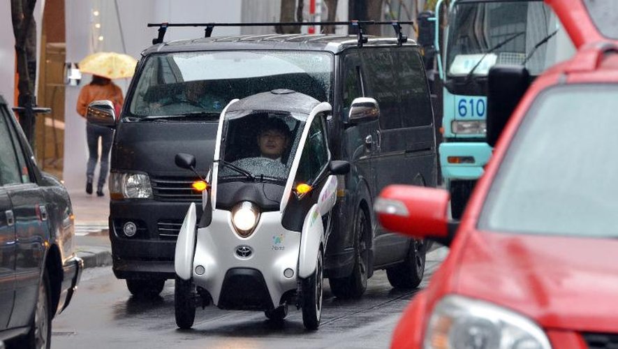 Une voiture i-road mise au point par Toyota circule dans les rues de Tokyo le 7 avril 2015