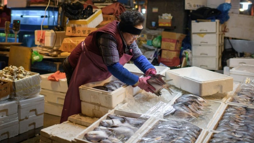 Un vendeur de poissons dispose son étal installé dans le marché aux poissons de Séoul, le 3 février 2016
