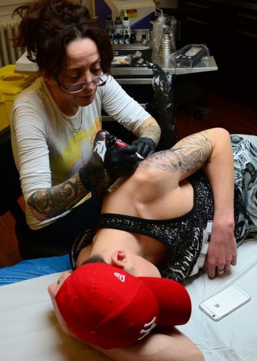 La tatoueuse Corinne Dubosque tatoue le bras de Timothée dans son atelier à  Plessis-Trévise, près de Paris le 9 février 2016