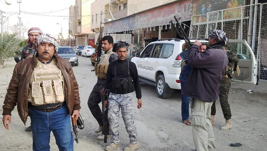 Des policiers irakiens et des civils armés se tiennent dans une rue de Ramadi, le 2 janvier 2013