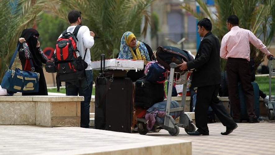 Des gens portent leurs valises à l'aéroport de Sanaa pour fuir le pays le 8 avril 2015