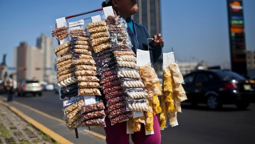 Une femme vend des snacks au bord d'une avenue de Lima, le 27 décembre 2013