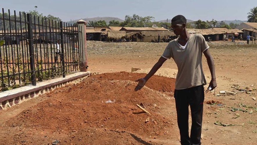 Un homme montre les tombes de membres de la communauté musulmane tués dans le district PK13 du nord de Bangui, le 3 janvier 2014