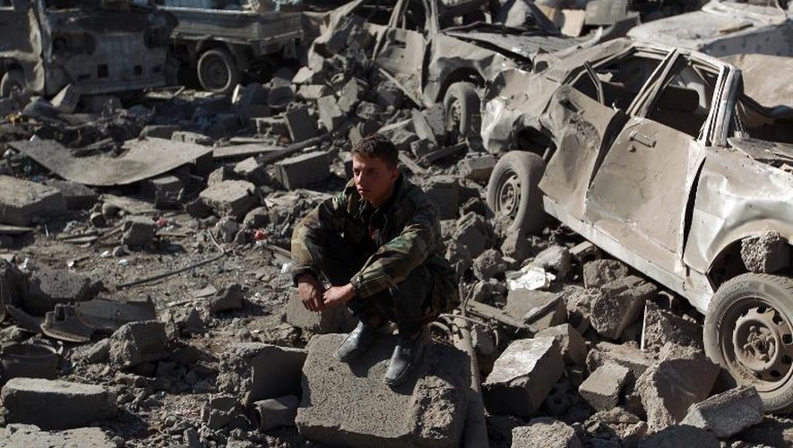 Un Yéménite assis au milieu des débris sur le site d'un bombardement aérien de l'Arabie saoudite près de l'aéroport de Sanaa le 26 mars 2015