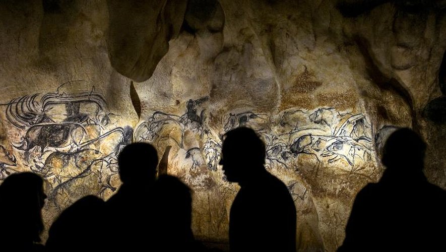 Des gens regardent la reproduction de fresque de la grotte Chauvet à Vallon Pont D'Arc le 8 avril 2015