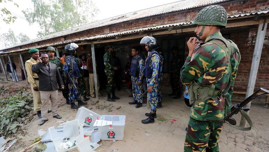 Des policiers devant un bureau de vote saccagé le 5 janvier 2014 à Bogra dans le nord du Bangladesh