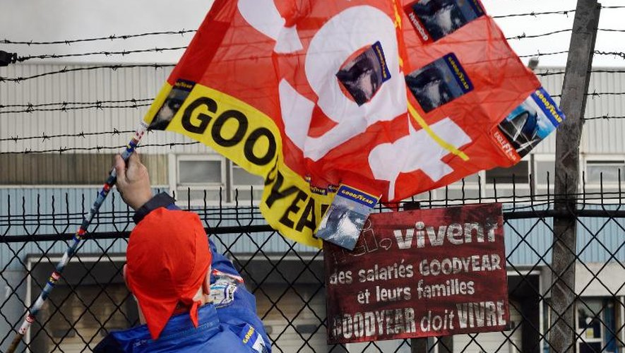 Un salarié agite un drapeau de la CGT devant l'usine Goodyear d'Amiens, le 5 décembre 2013, après l'annonce de la fermeture du site
