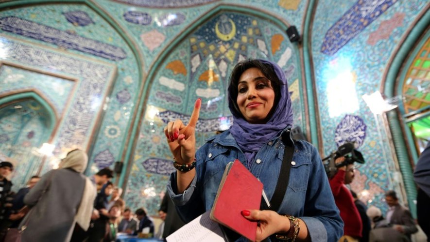 Une femme iranienne montre son doigt encré après avoir voté le 26 février 2016 à Téhéran