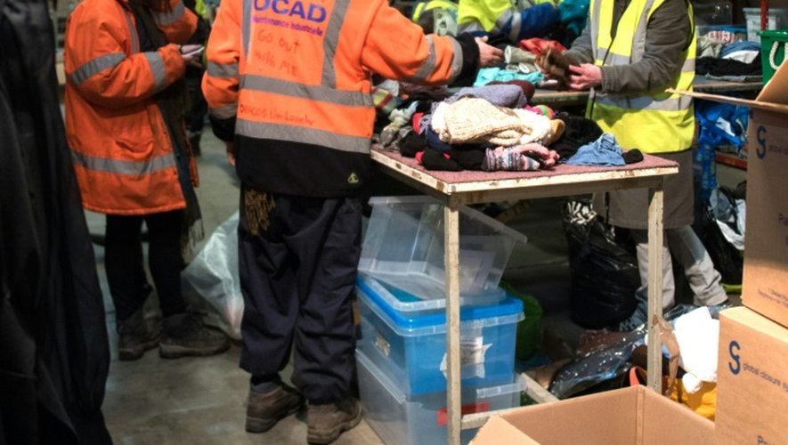 Des bénévoles trient des vêtements dans le hangar de "l'Auberge des Migrants", le 22 février 2016 à Calais