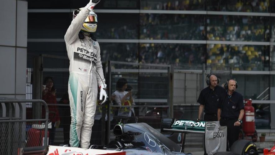 Le pilote britannique de l'écurie Mercedes-AMG Lewis Hamilton salue ses fans après avoir décroché la pole position du Grand Prix de Chine, sur le circuit de Shanghai, le 11 avril 2015