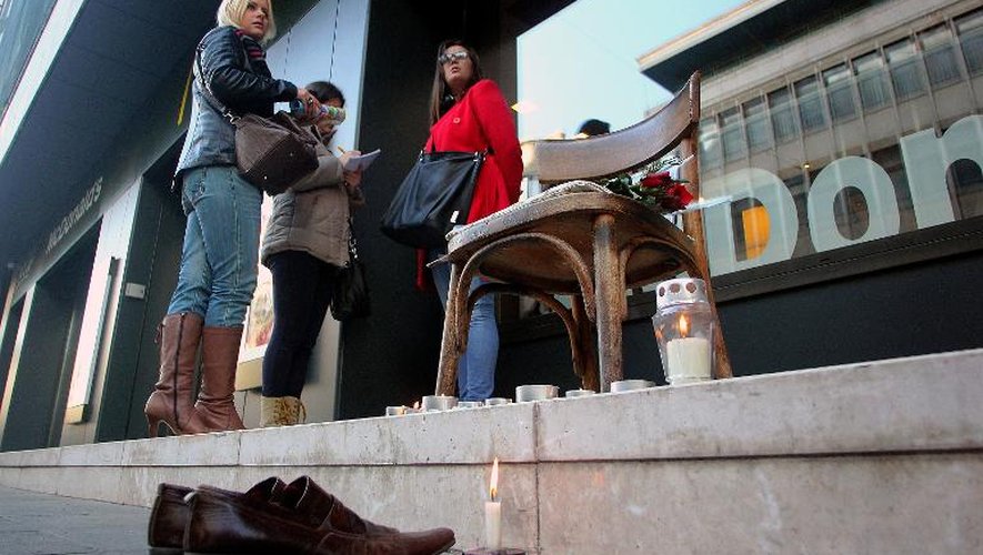 Des femmes se tiennent près d'un petit mémorial disposé pour "Oncle Miso", le dernier cireur de chaussures, le 7 janvier 2014 à Sarajevo