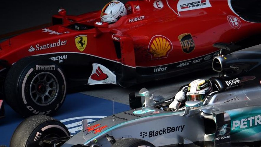 Lewis Hamilton (g) dans sa Mercedes devant la Ferrari de Sebastian Vettel à l'arrivée du Grand Prix de Chine à Shanghai, le 12 avril 2015