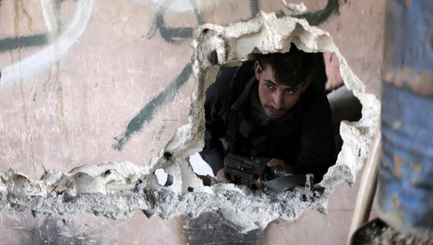 Un combattant syrien appartenant à un groupe rebelle sort d'un abri à Arbin dans les environs de Damas, le 26 février 2016