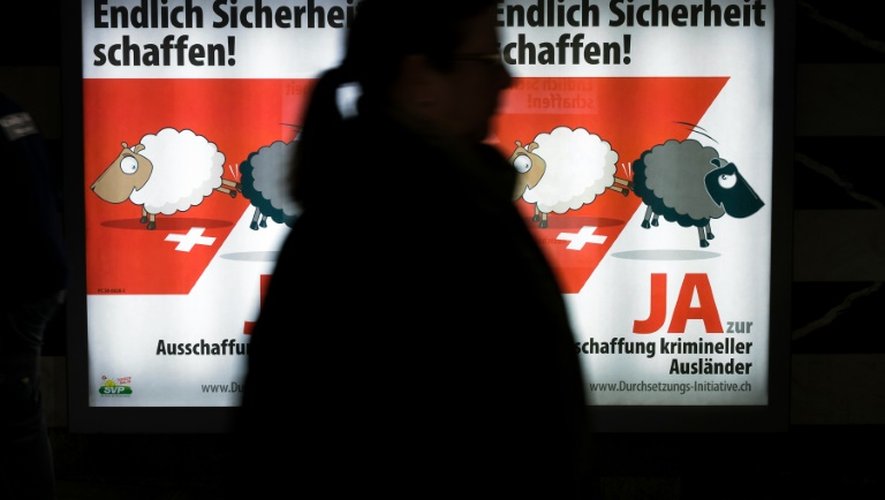 Une femme passe devant une affiche du parti du peuple suisse (Schweizerische Volkspartei - SVP) qui prône d'expulser automatiquement les criminels étrangers, à Zurich le 25 février 2016