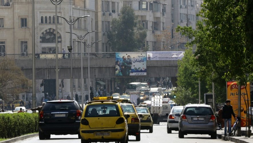 Des véhicules circulent dans une rue de Damas le 27 février 2016