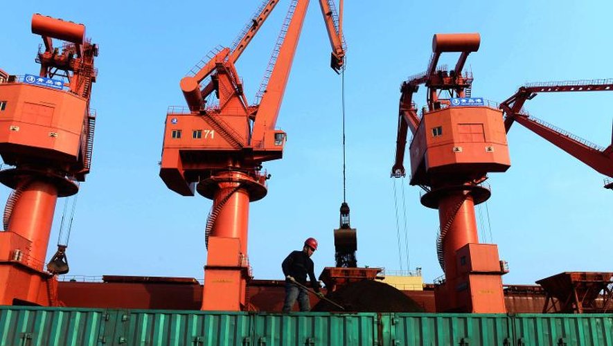 Un travailleur charge du minerai de fer sur un camion, le 13 avril 2015 dans le port de Qingdao, dans la province du Shandong
