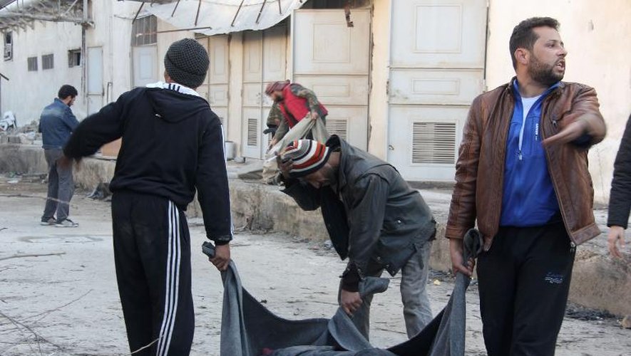 Des rebelles transportent le corps d'une victime à Alep, le 8 janvier 2014